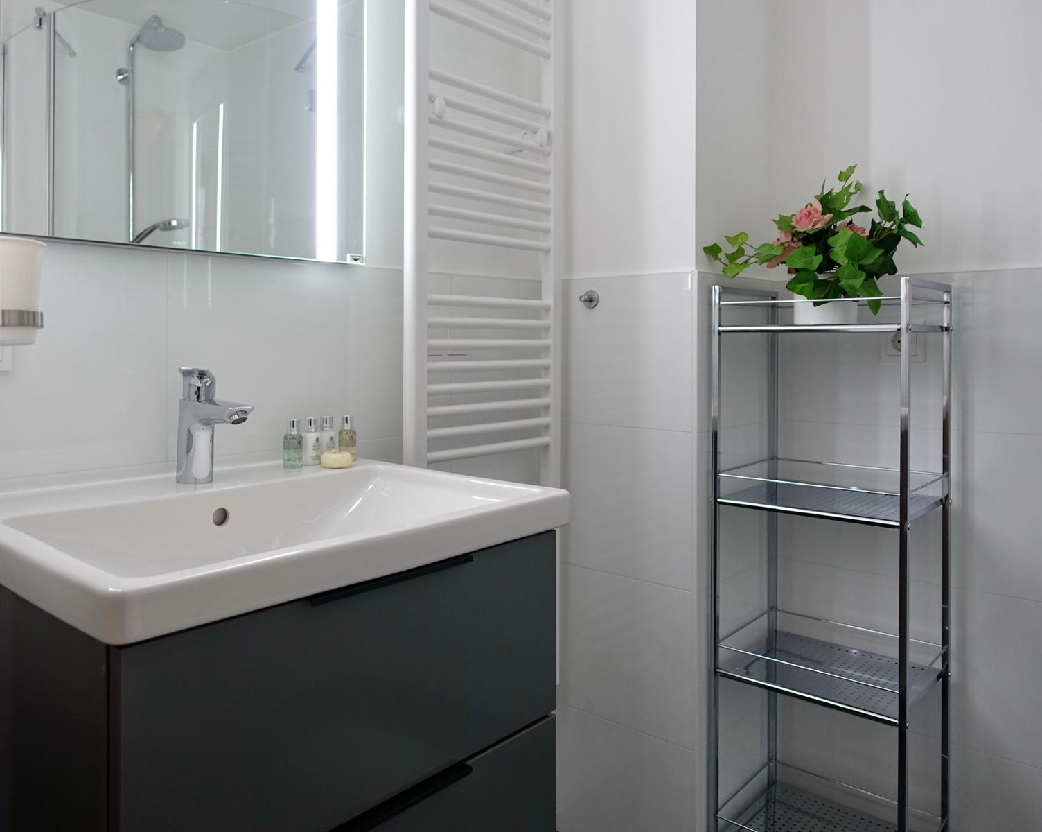 Bathroom with sink, mirror, and shelf.