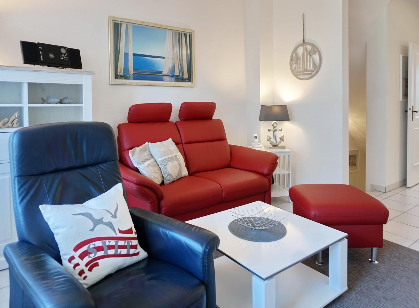 Red sofa, blue armchair, and white coffee table in the living room