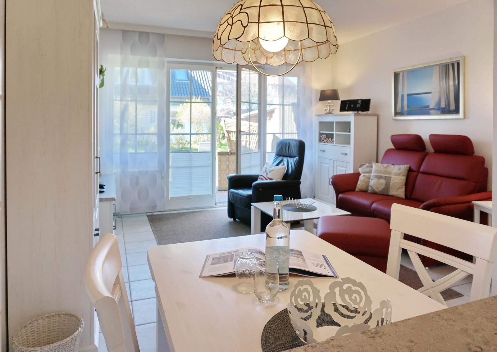 Living and dining area with red sofa, dining table, and glass ceiling.