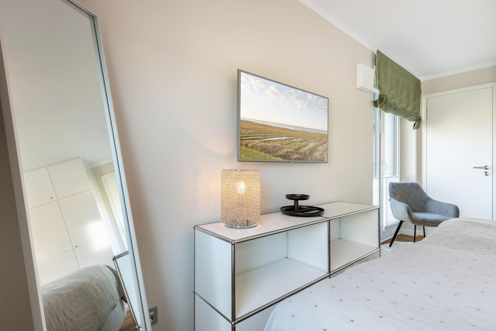 Schlafzimmer mit Bett, Schrank, Fernseher und Stuhl