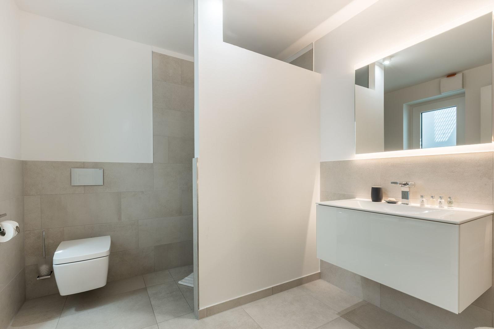 Moderne Badezimmer mit Toilette, Waschbecken und Dusche.