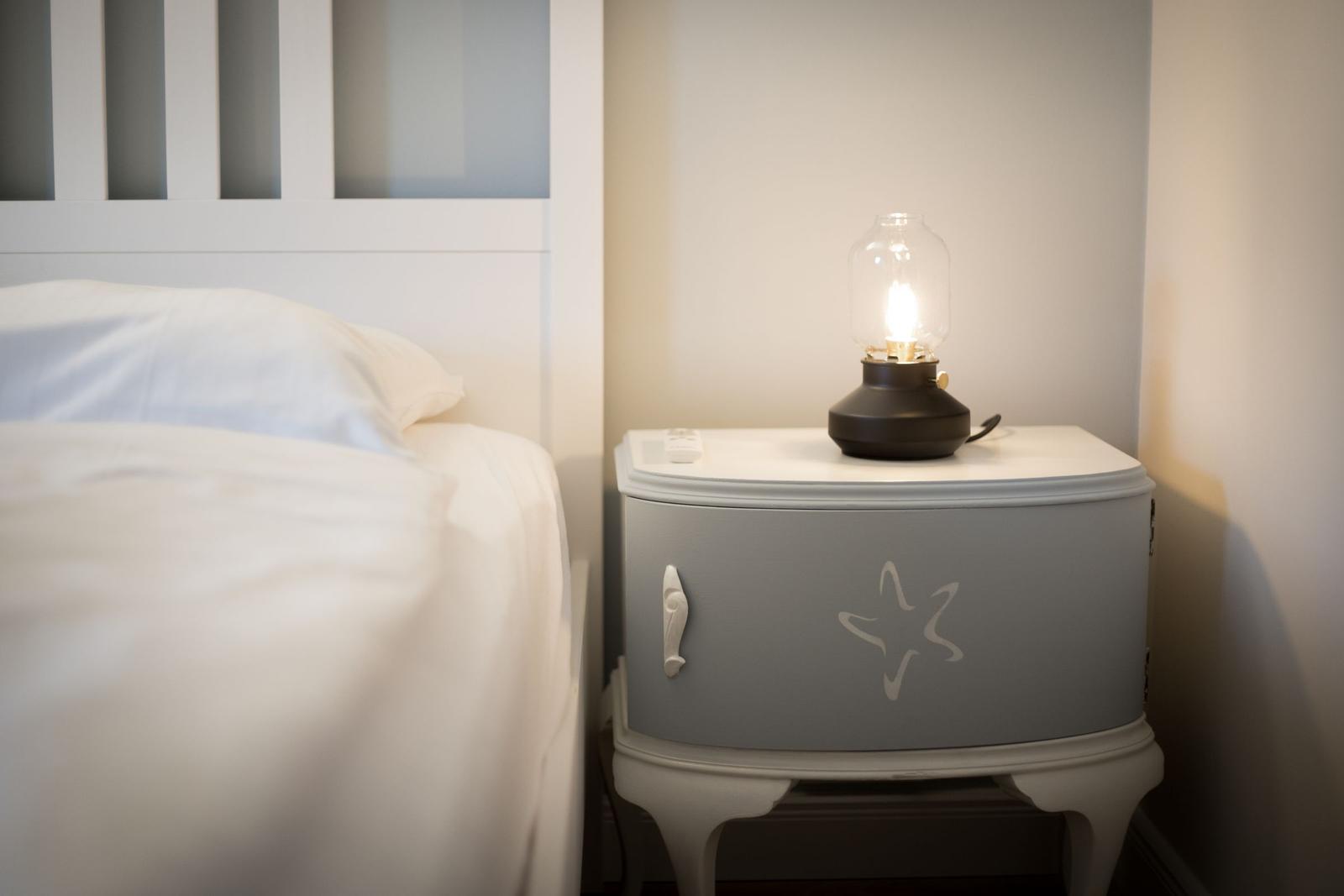 Schlafzimmer mit Bett und Nachttisch mit Lampe