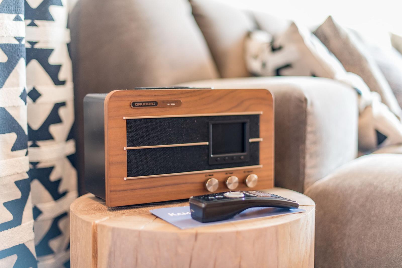 Holztablett mit Radio und Fernbedienung vor Sofa