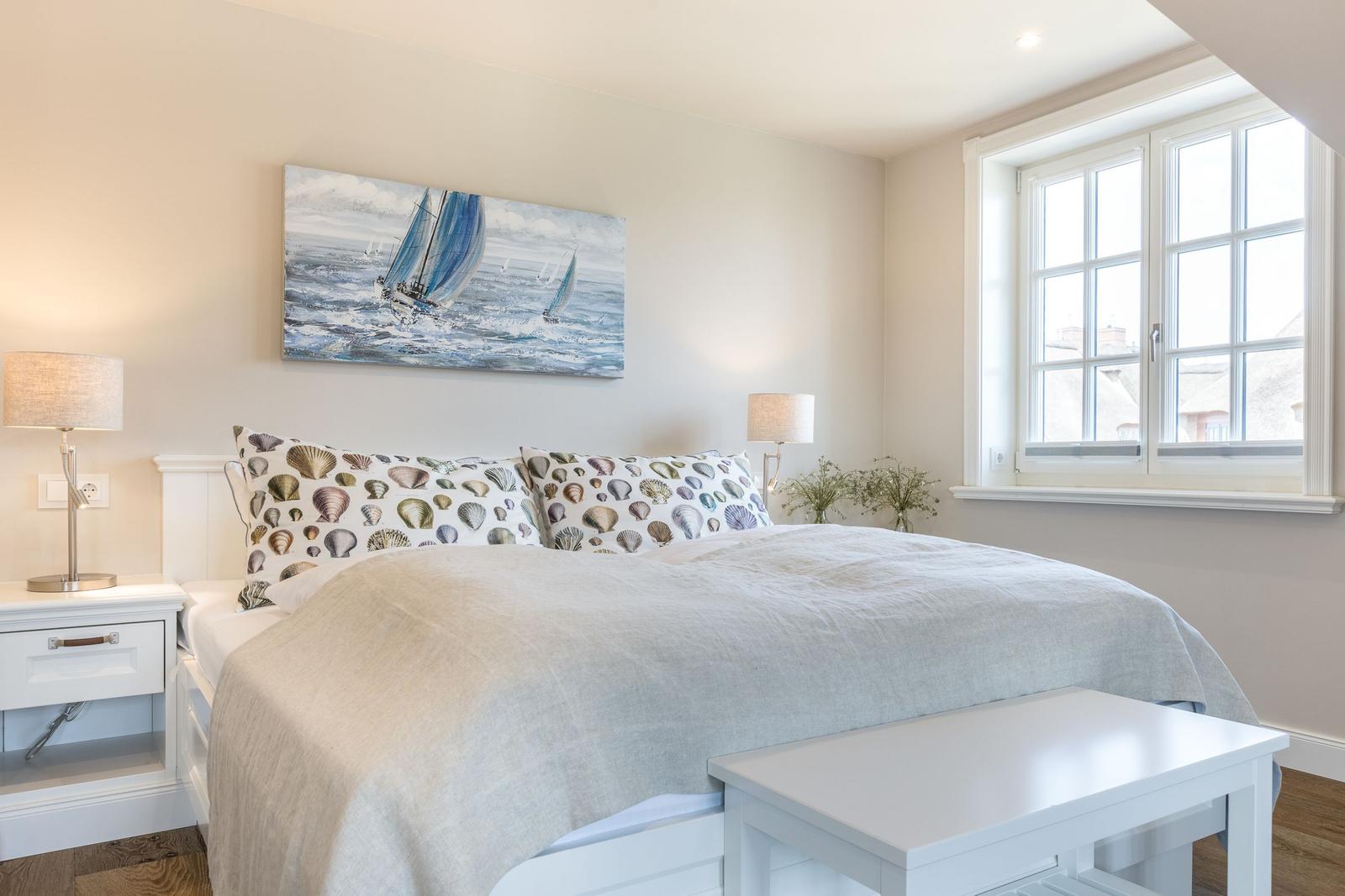 Schlafzimmer mit Bett, Fenster und Wandbild mit Segelbooten.
