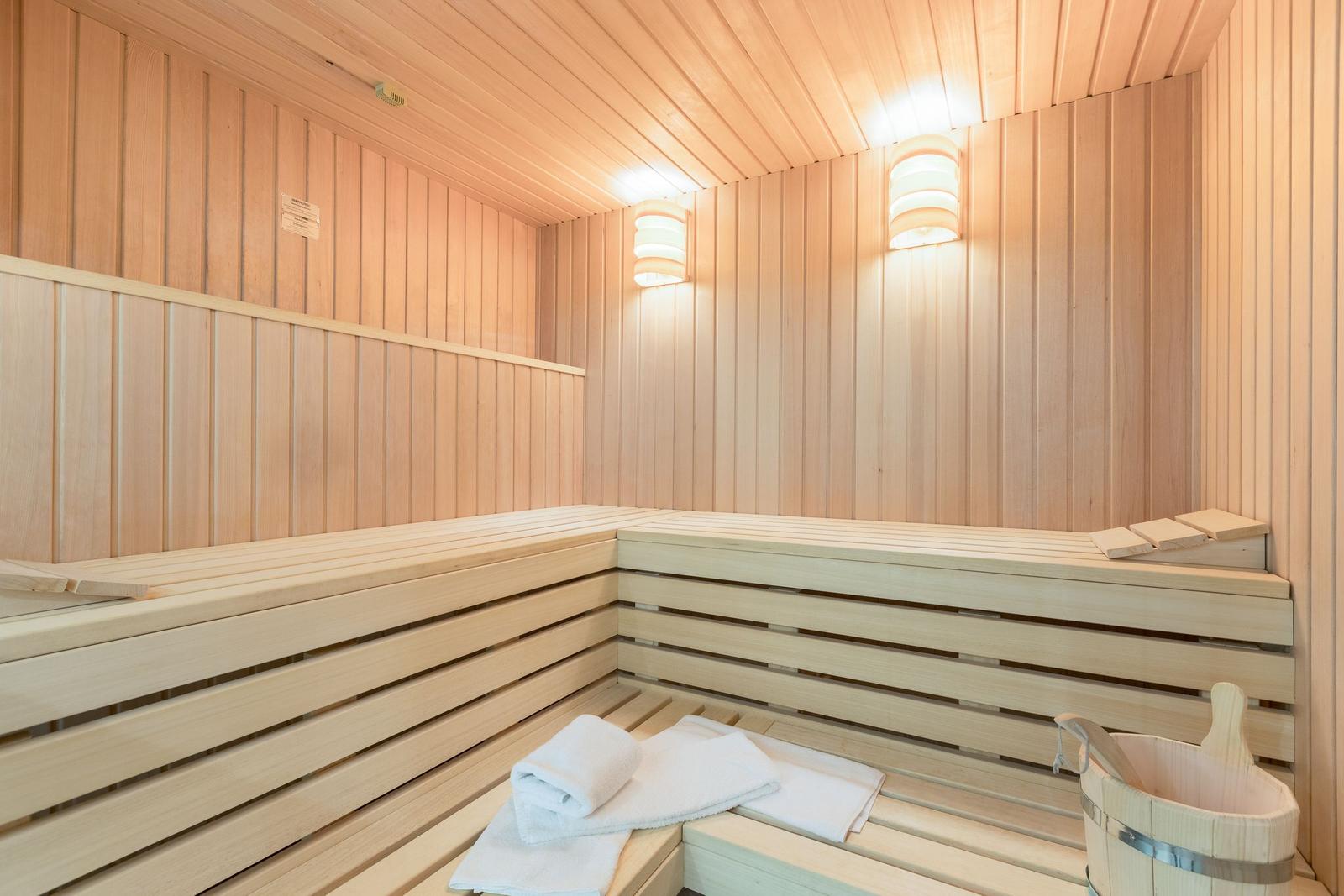 Sauna mit Holzbank und weißen Handtüchern