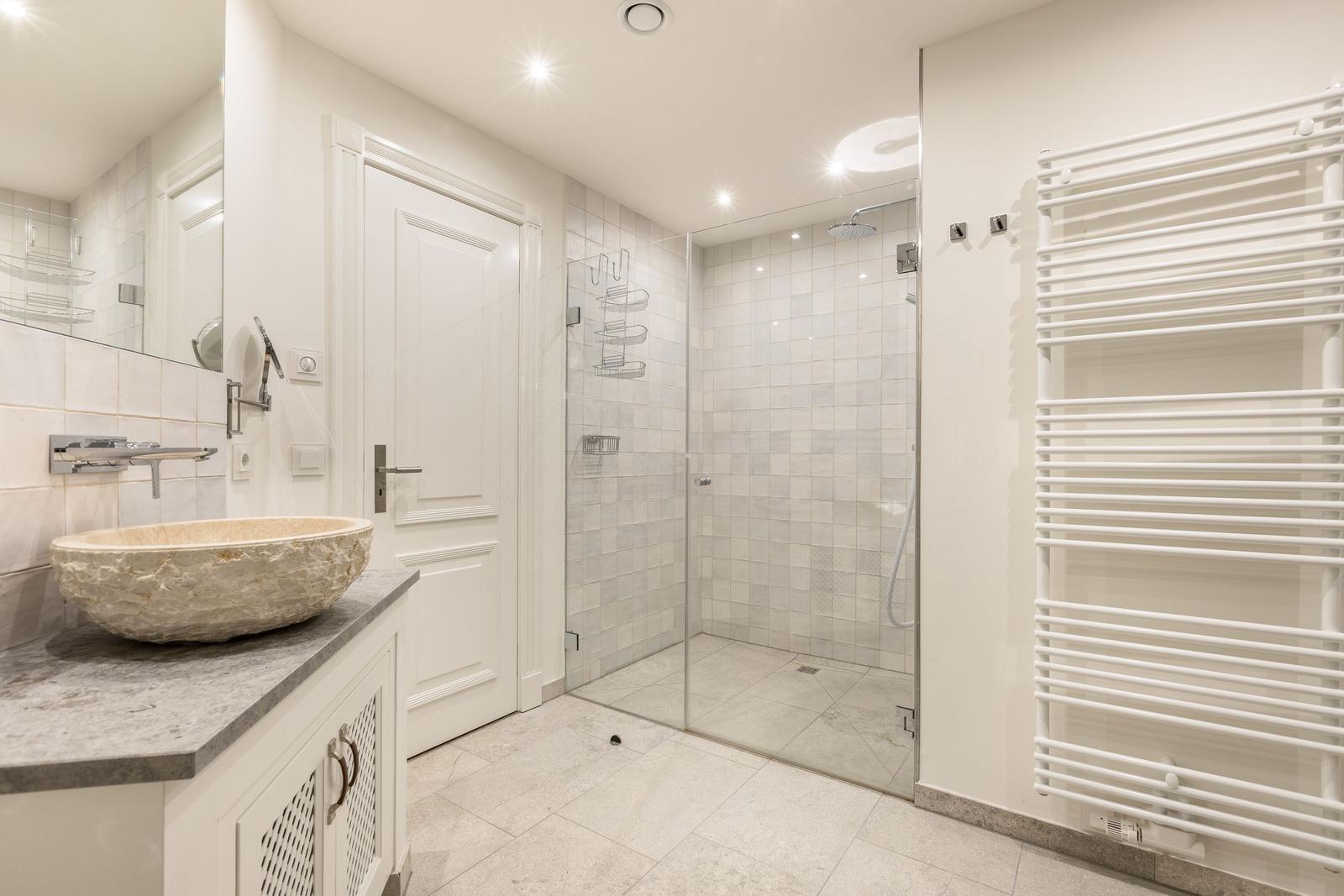 Badezimmer mit Dusche, Waschtisch und Heizkörper