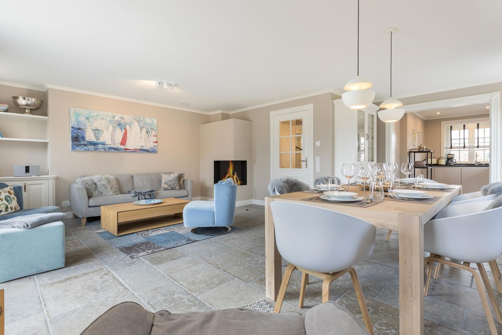 Wohn- und Essbereich mit Kamin, Esstisch und Sofa.