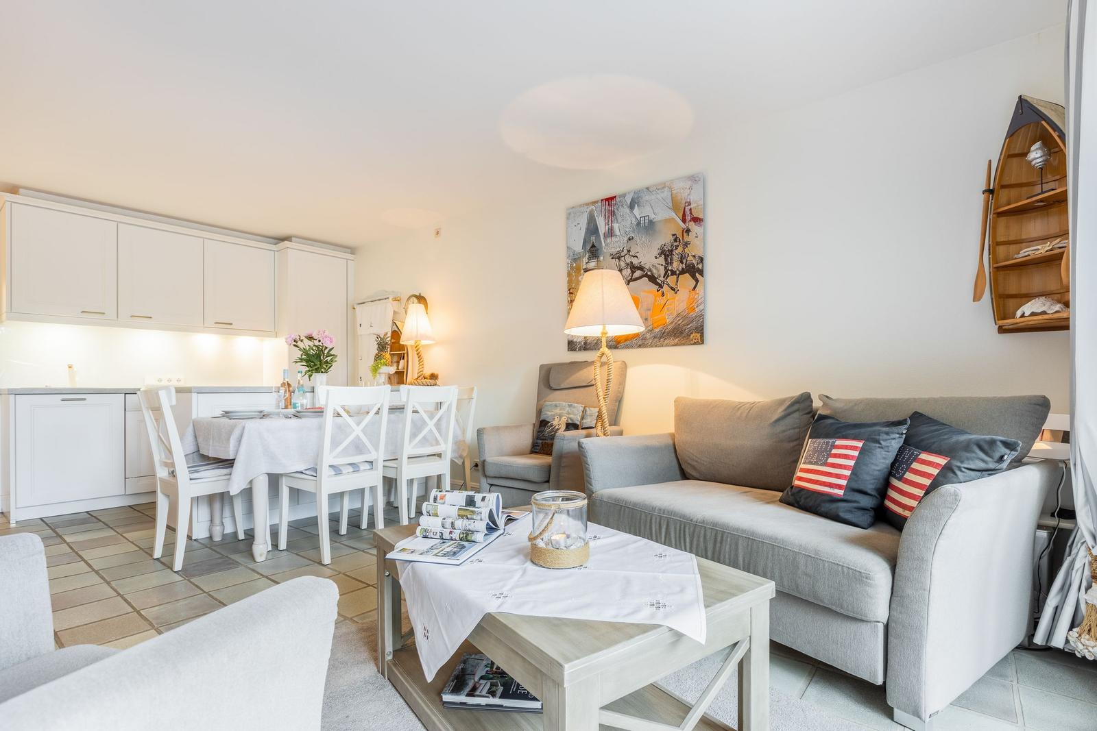 Wohn- und Essbereich mit Sofa, Tisch und Küchenzeile.