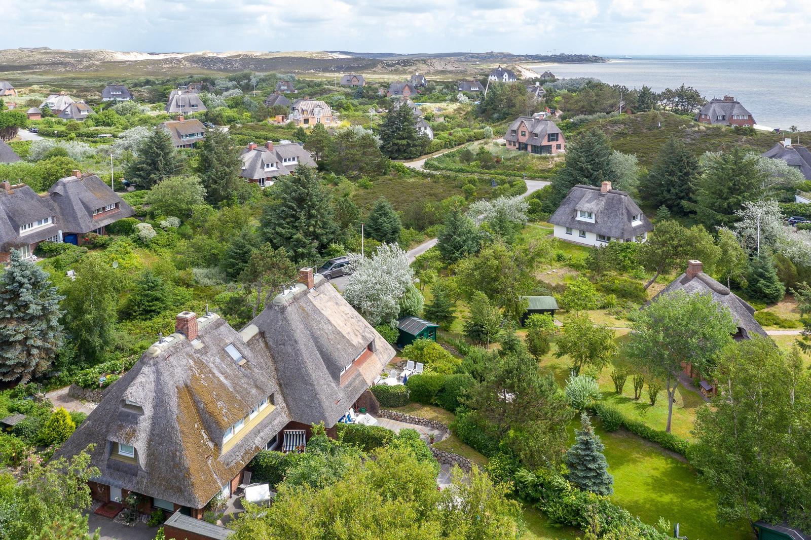 Dorf mit Strohdächern, Grünflächen und Meerblick