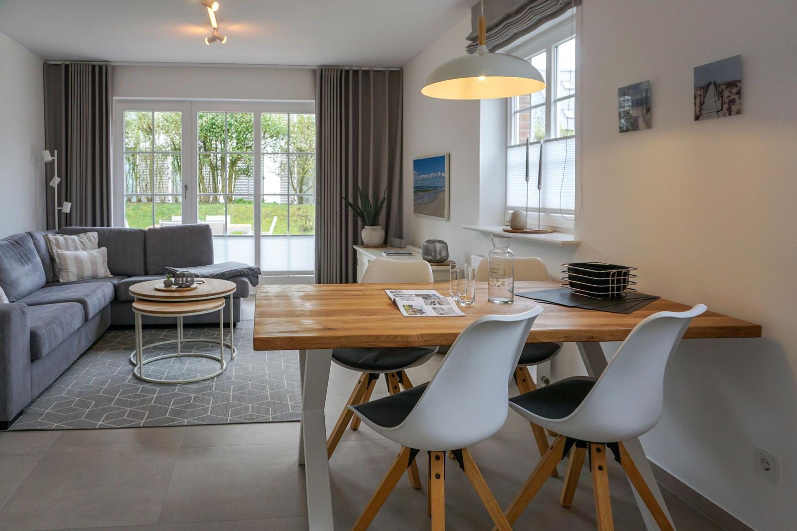 Wohn- und Essbereich mit Sofa, Esstisch und Fenster zur Terrasse.