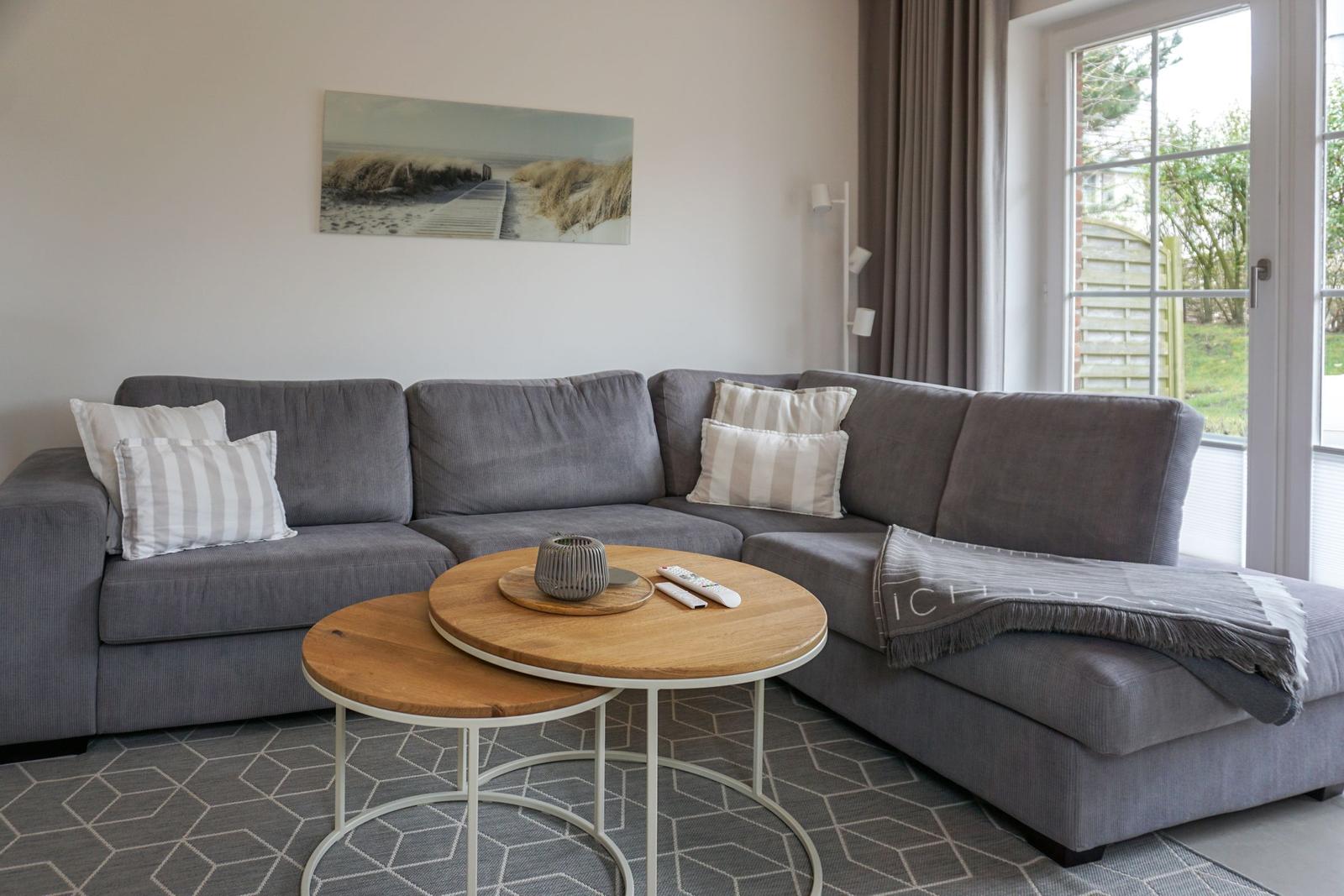 Graue Eckcouch mit Kissen und Tisch im Wohnzimmer.
