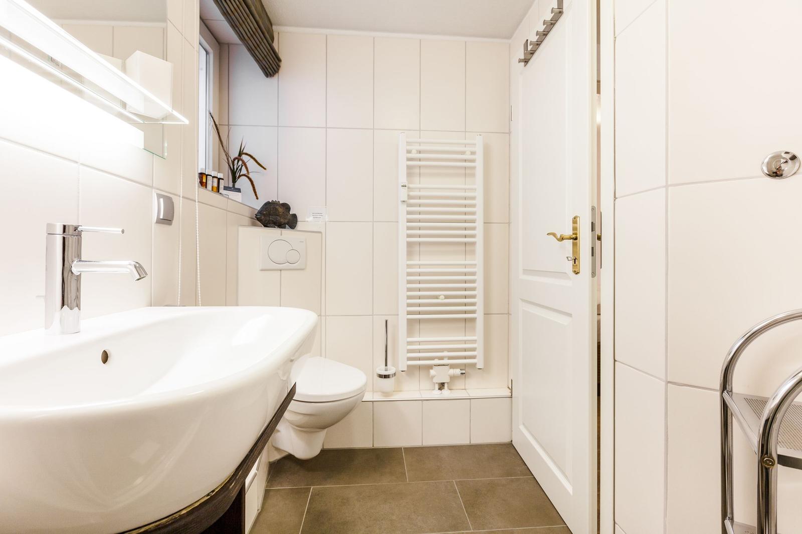 Bathroom with sink, toilet, and heater