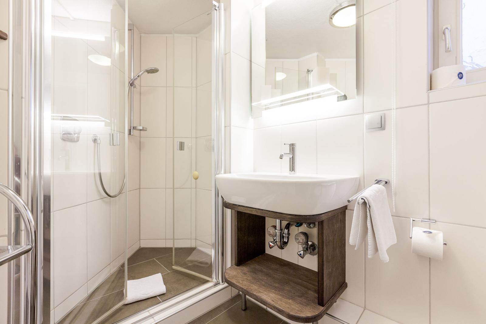 Bathroom with shower, sink, and mirror