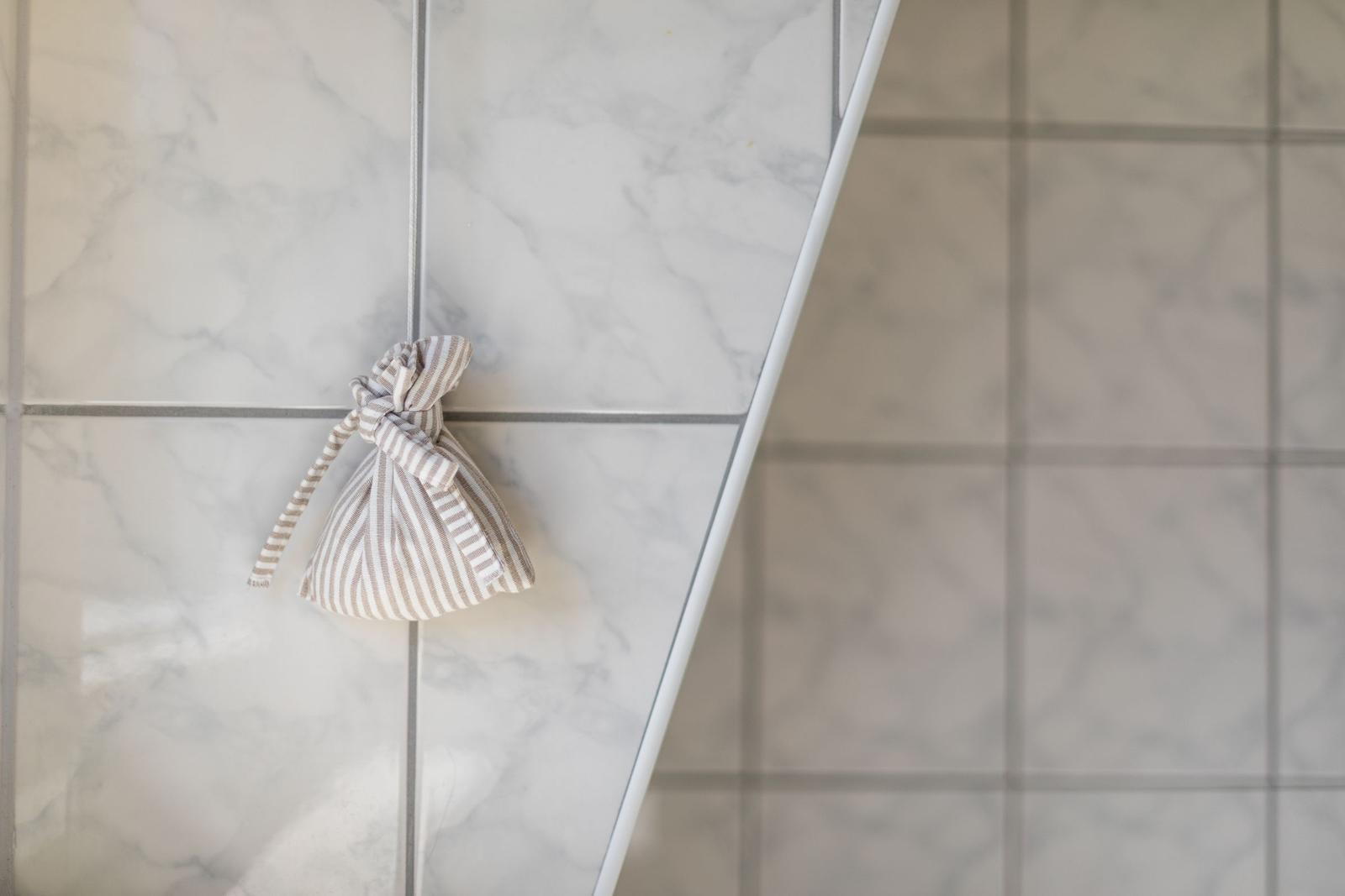 Geschirrtasche hängt an einer Wand mit Marmorfliesen.
