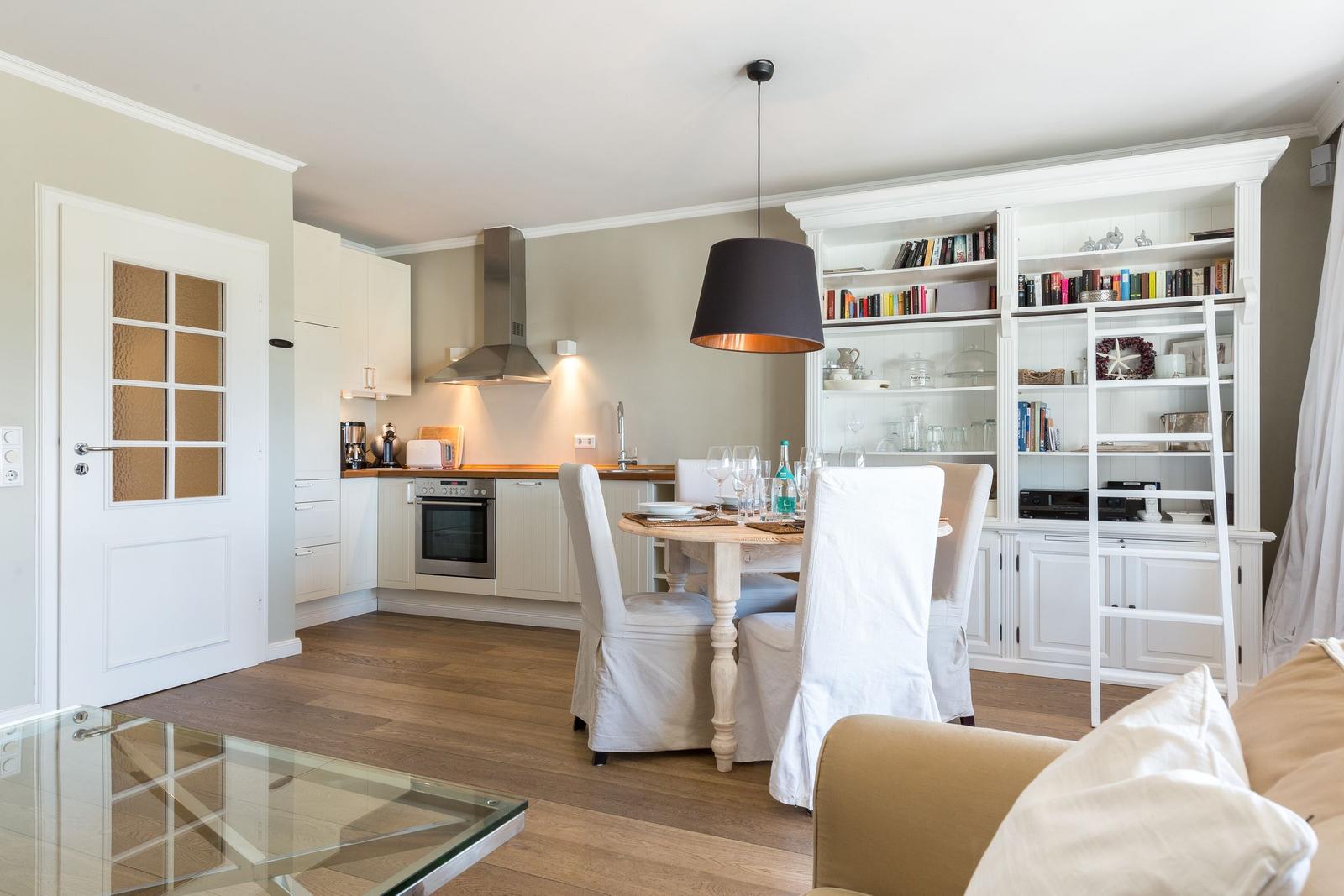 Kitchen with dining area and bookcase in the background.