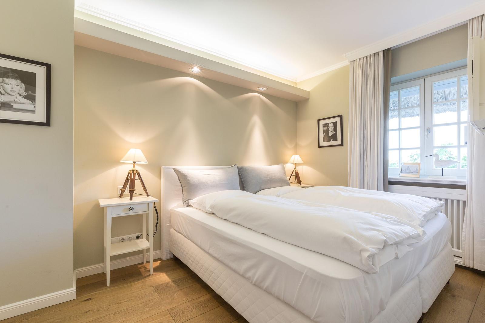 Bedroom with bed, nightstands, and window.