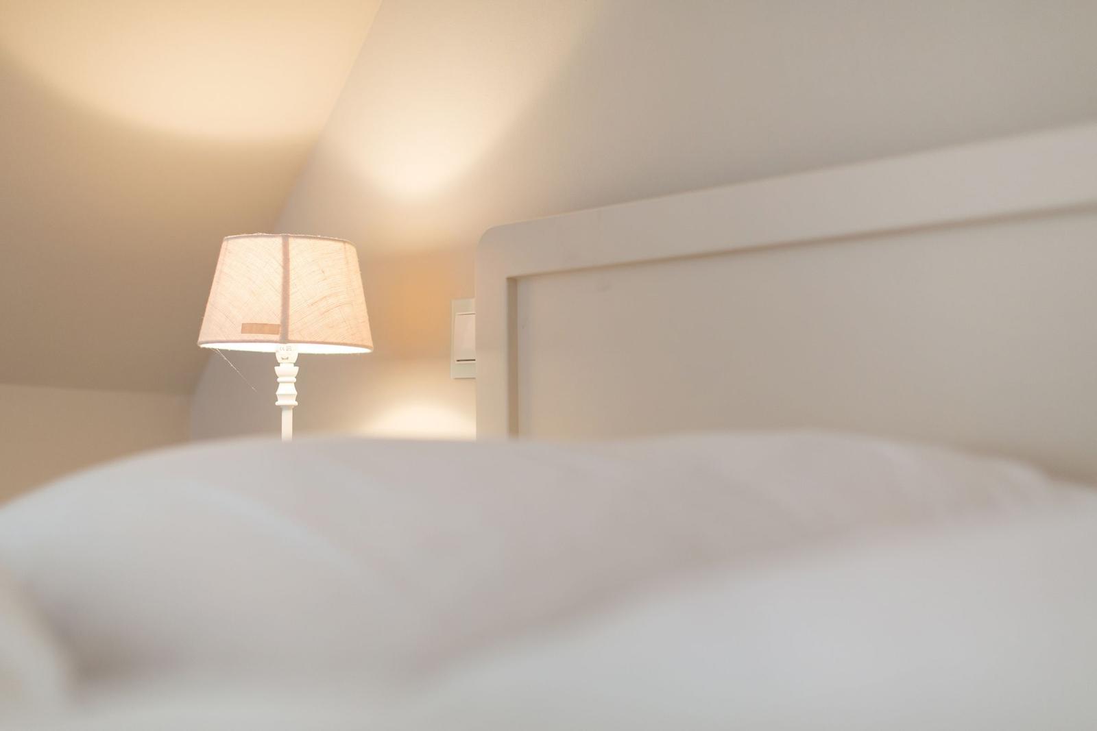 High-quality bed with white headboard and bedside lamp.