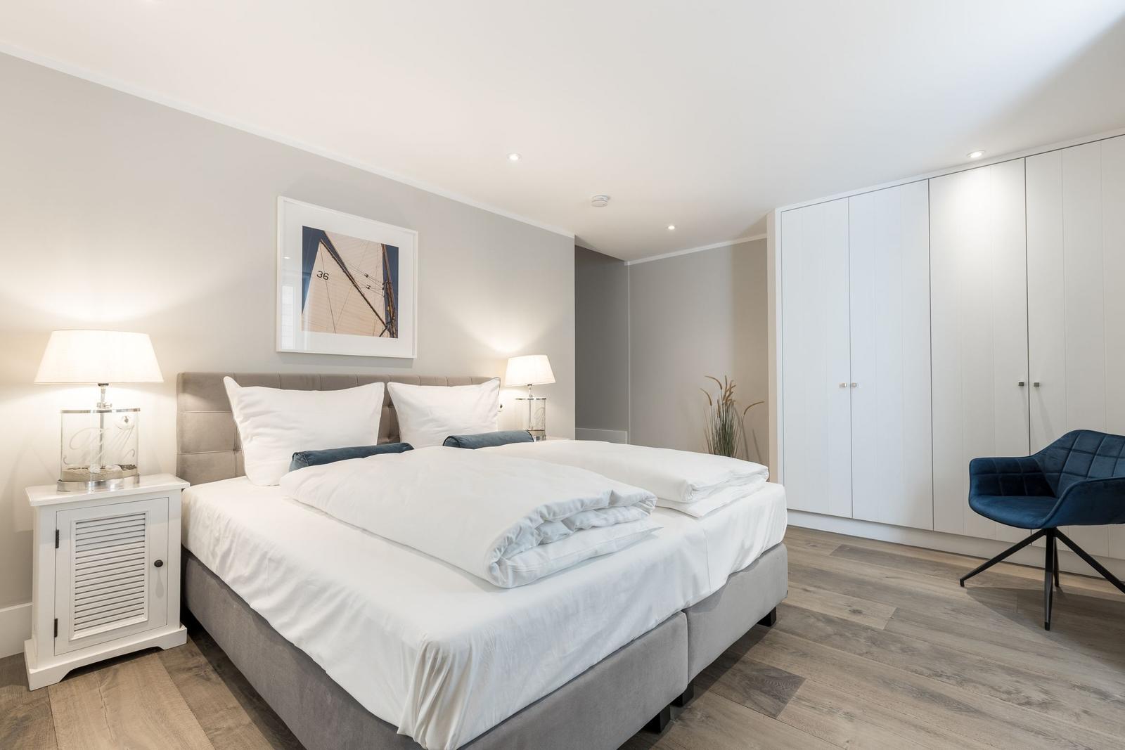 Schlafzimmer mit Doppelbett, Nachttischen und Kleiderschrank.