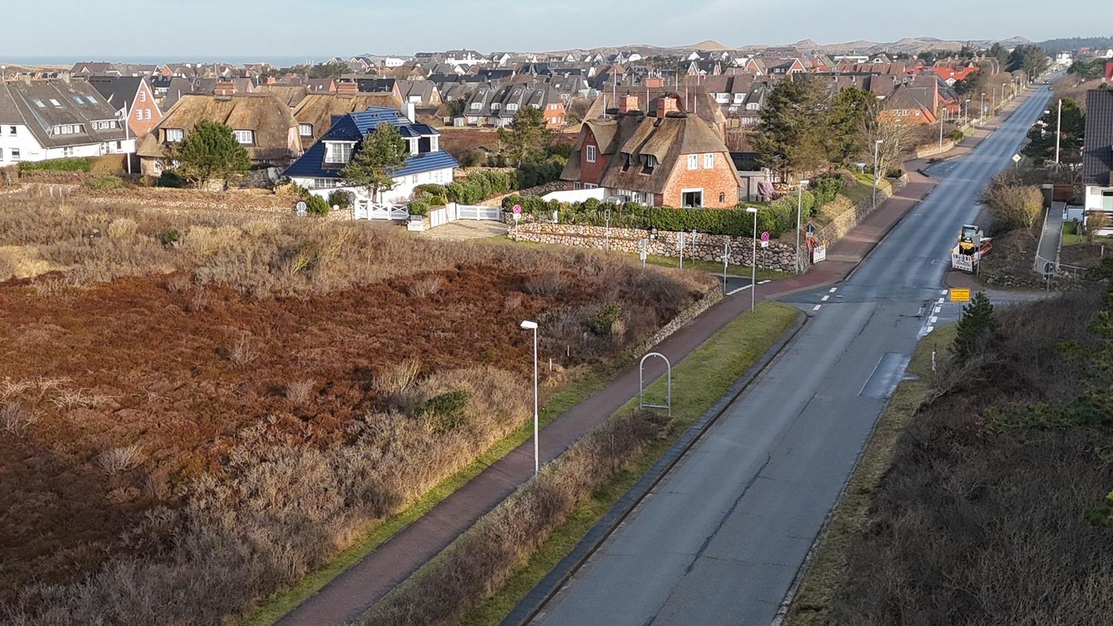 Straße mit Blick auf Häuser und Heideflächen
