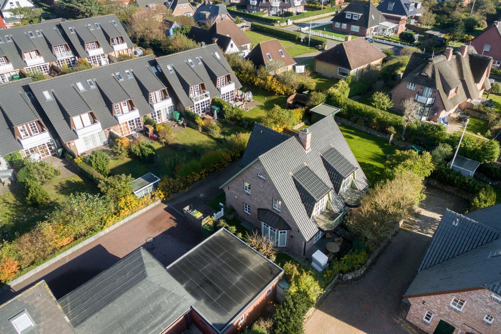 Luftbild von mehreren Häusern mit Gärten und Straßen in einer Wohngegend.