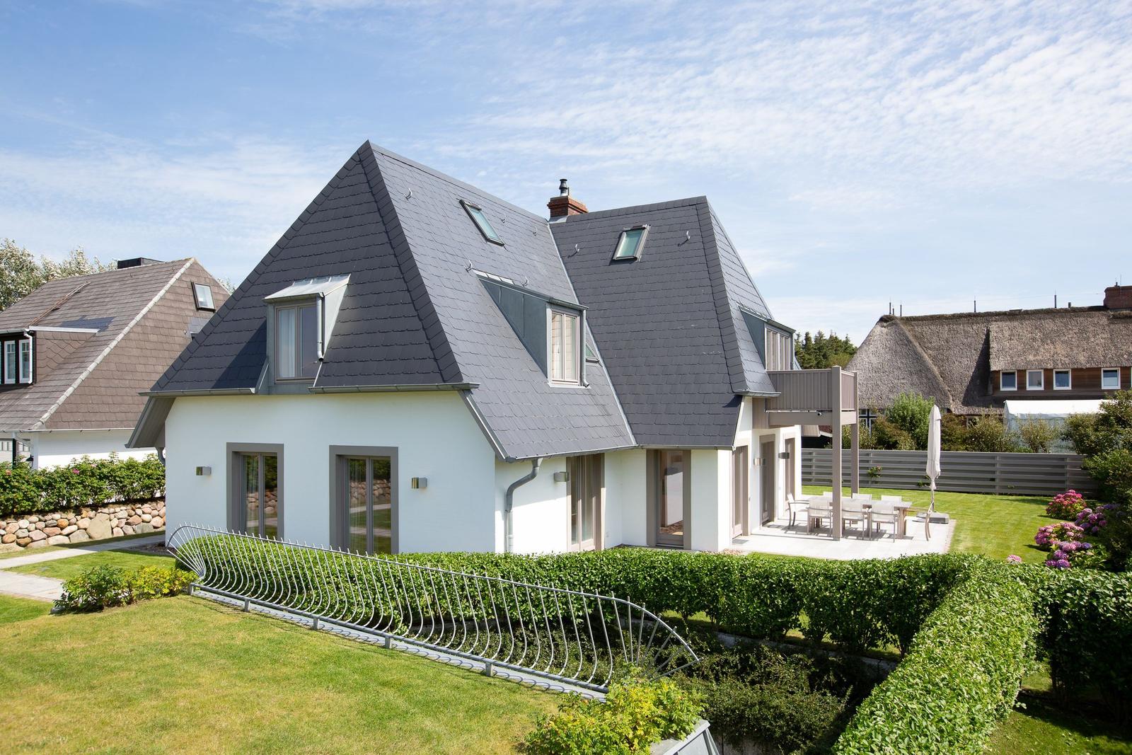 Modern villa with dormers and garden area with terrace.
