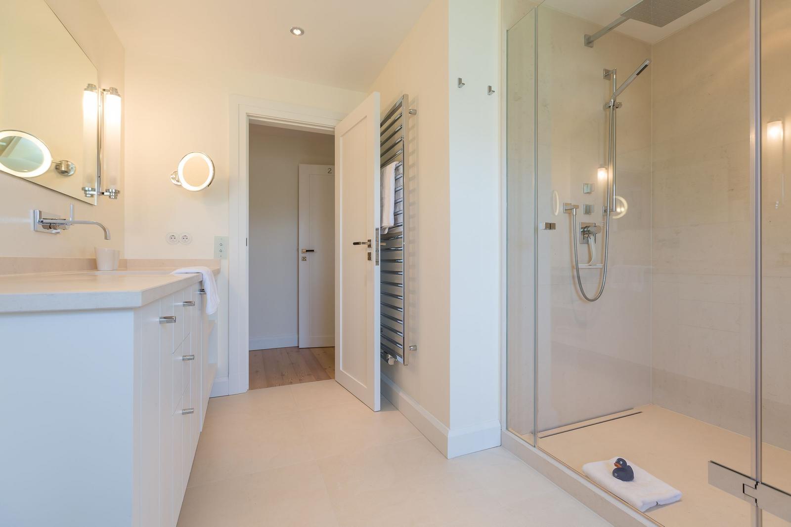 Bathroom with shower, sink, and heater.