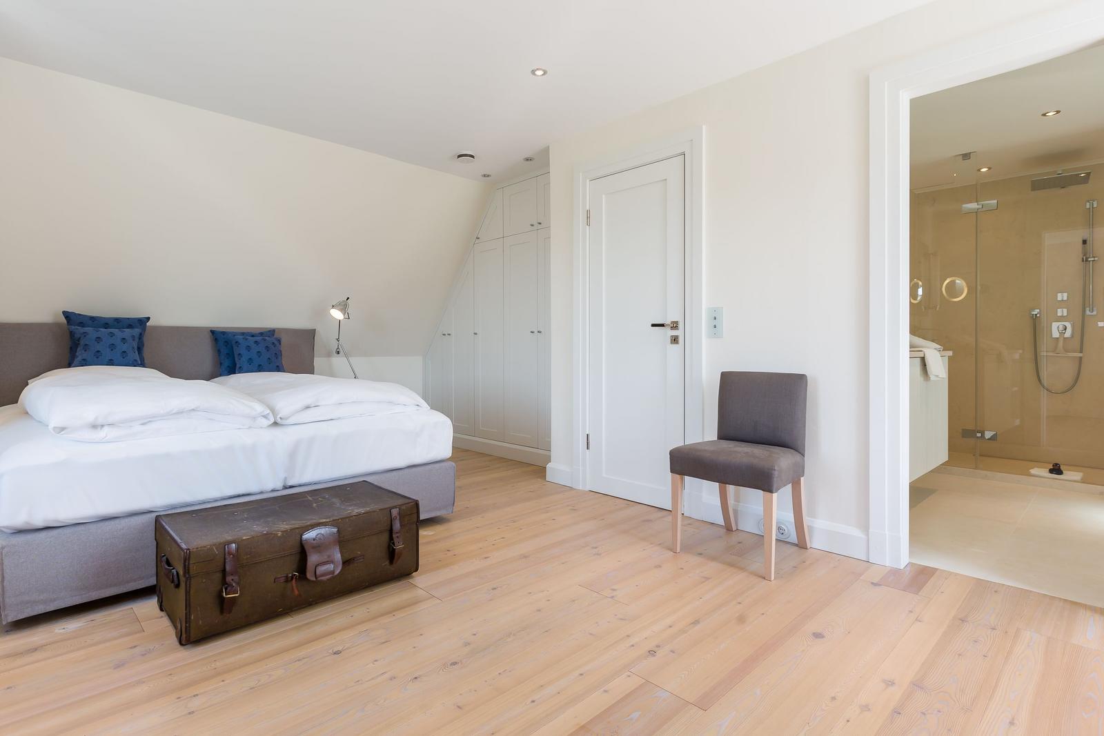 Bedroom with double bed, wardrobe, and bathroom with shower.