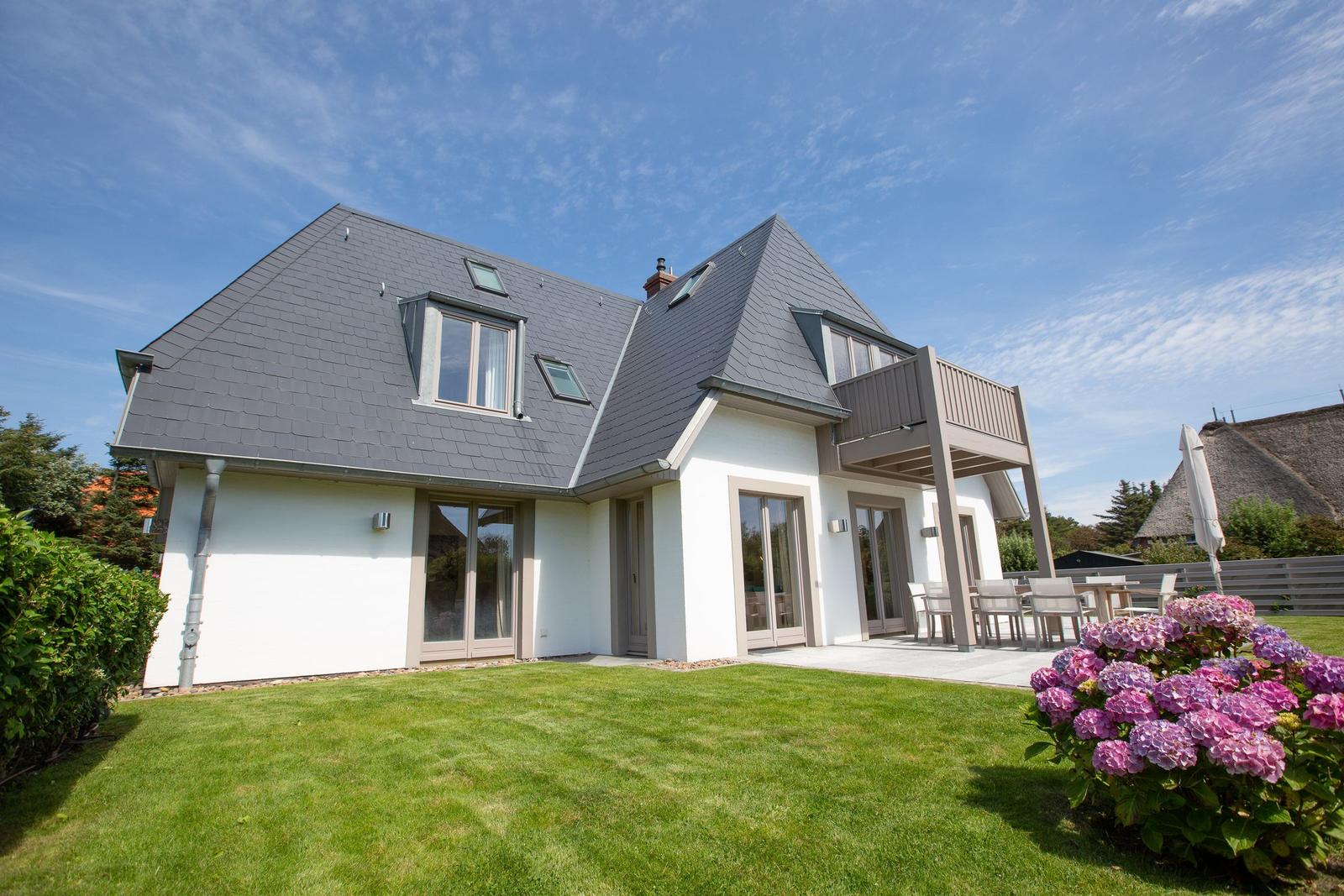 Modern house with terrace and garden. Flowerbeds and clear view.