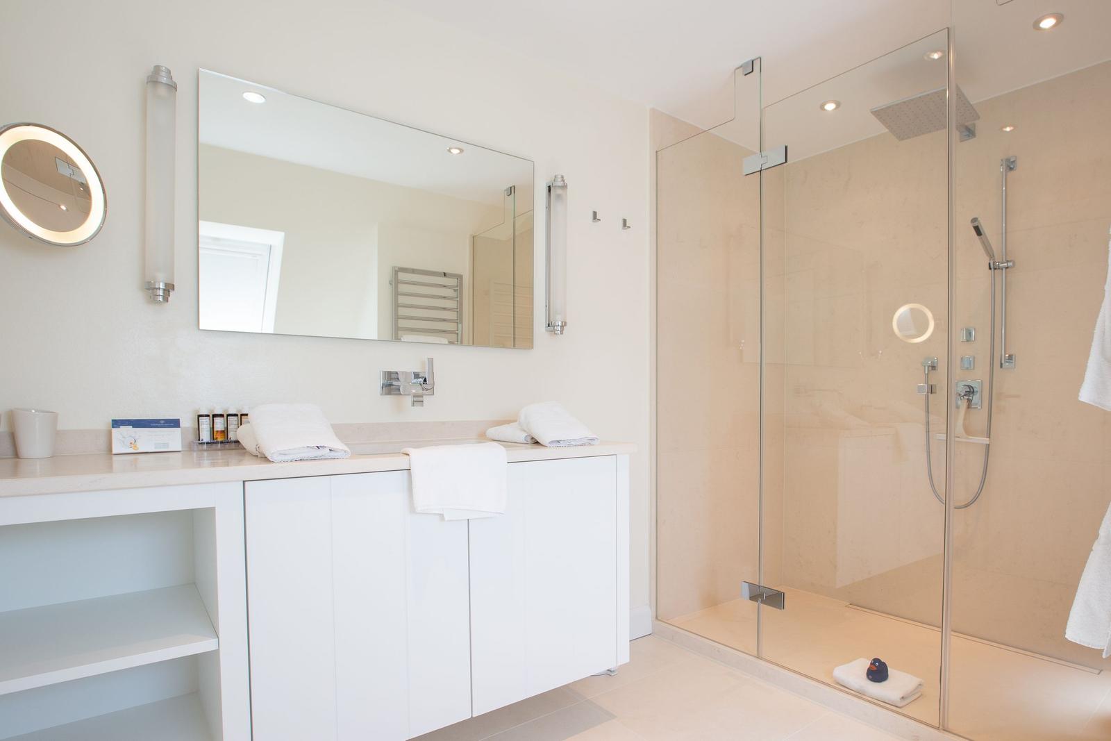 Bathroom with shower, sink, and mirrors