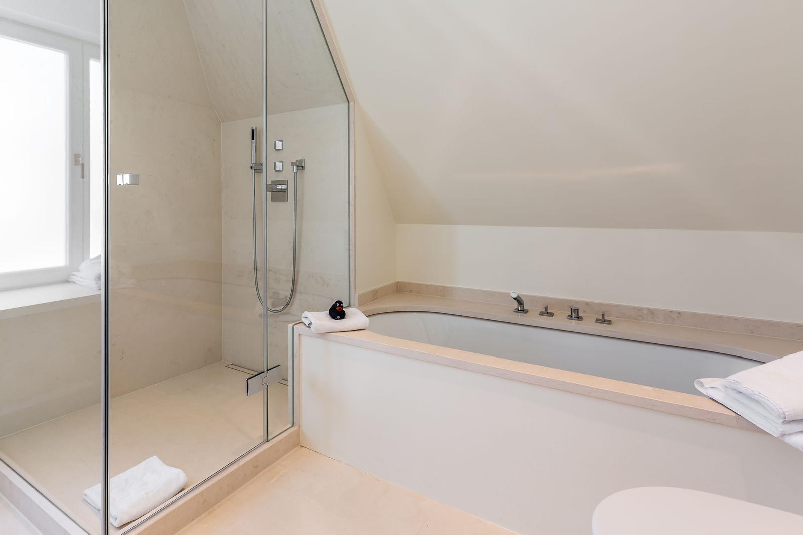 Bath with shower and bathtub under sloped ceiling
