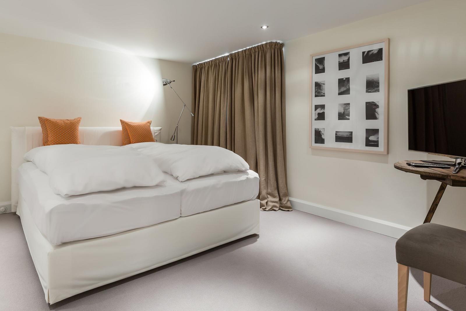 Bedroom with bed, curtains, and wall art