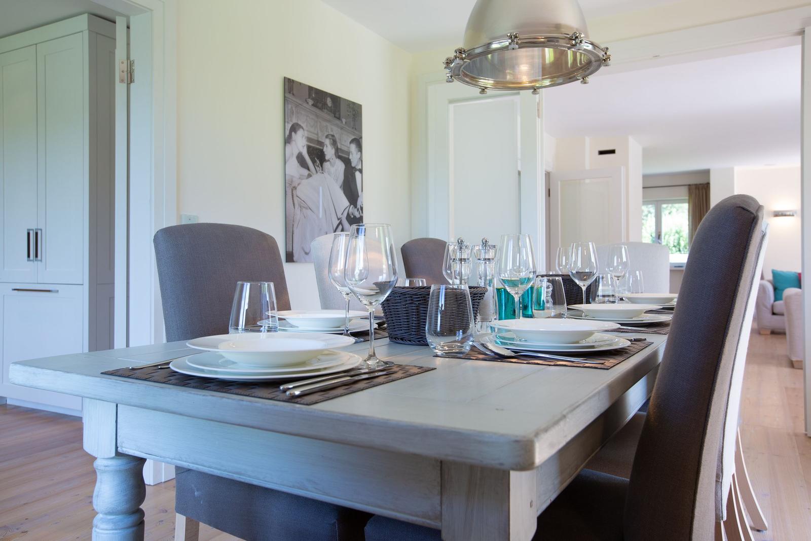 Dining table with chairs and tableware in dining area