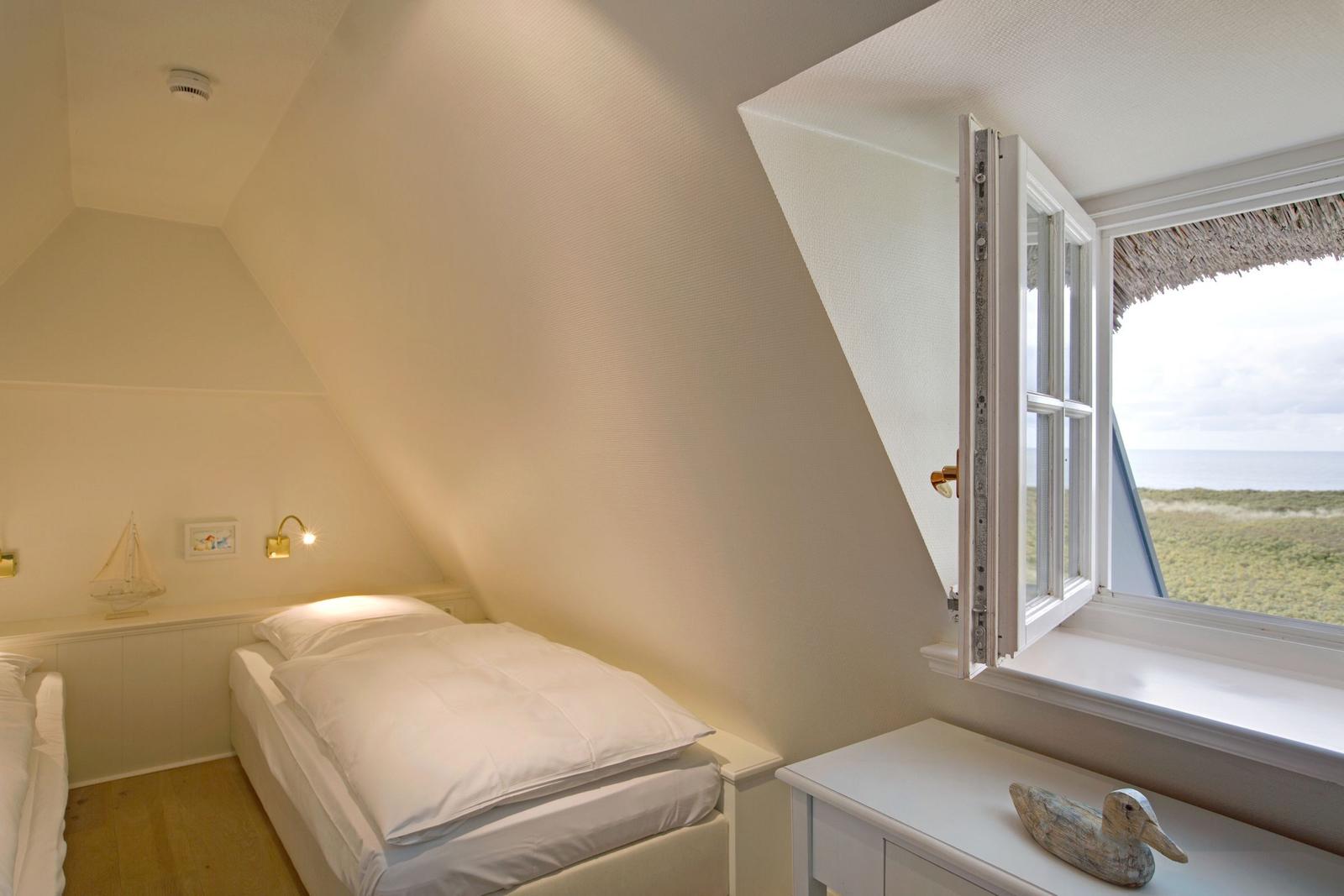 Schlafzimmer mit Dachfenster und Blick aufs Meer.