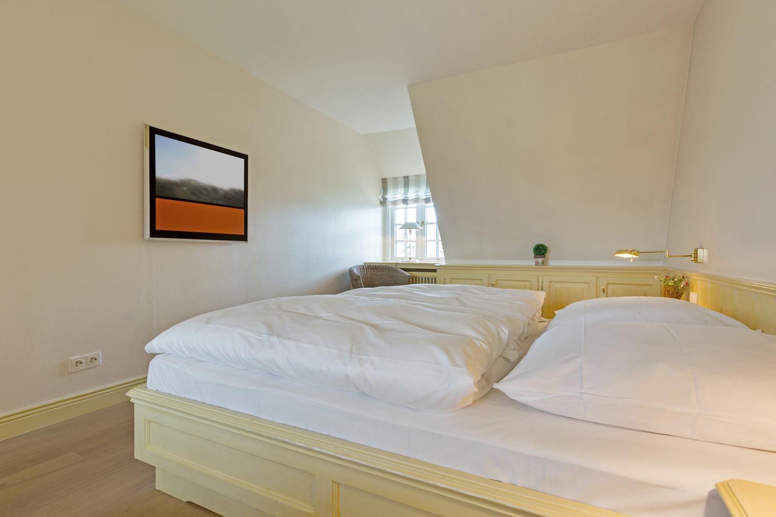 Schlafzimmer mit Doppelbett, Wandbild und Fenster mit Blick.