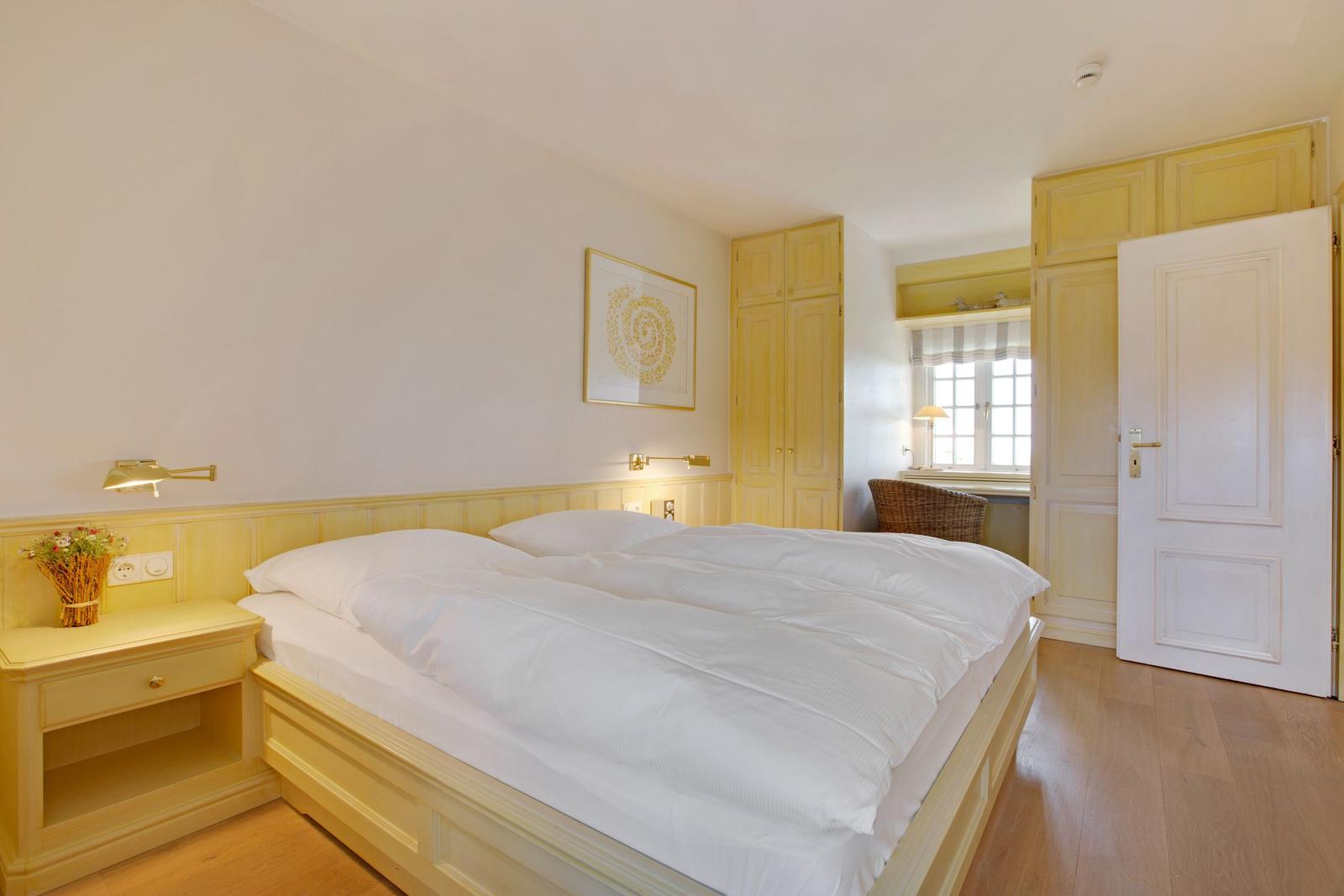 Schlafzimmer mit Doppelbett, Nachttisch und Fenster