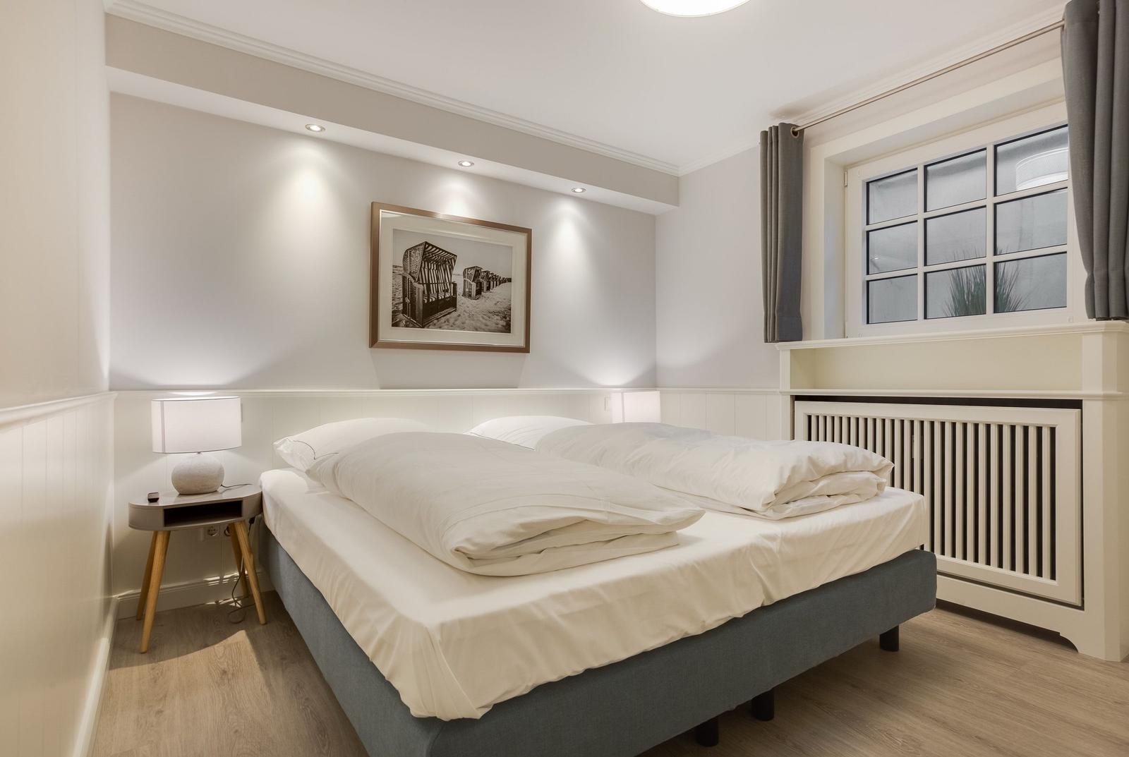 Bedroom with double bed, nightstand, and window.