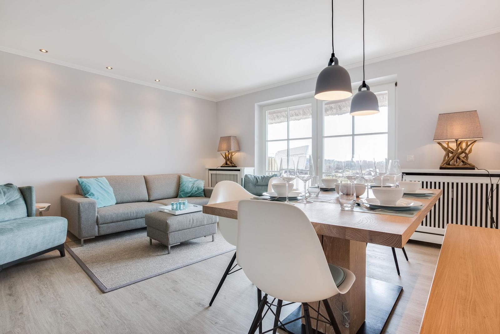 Living and dining area with sofa, dining table, and windows.