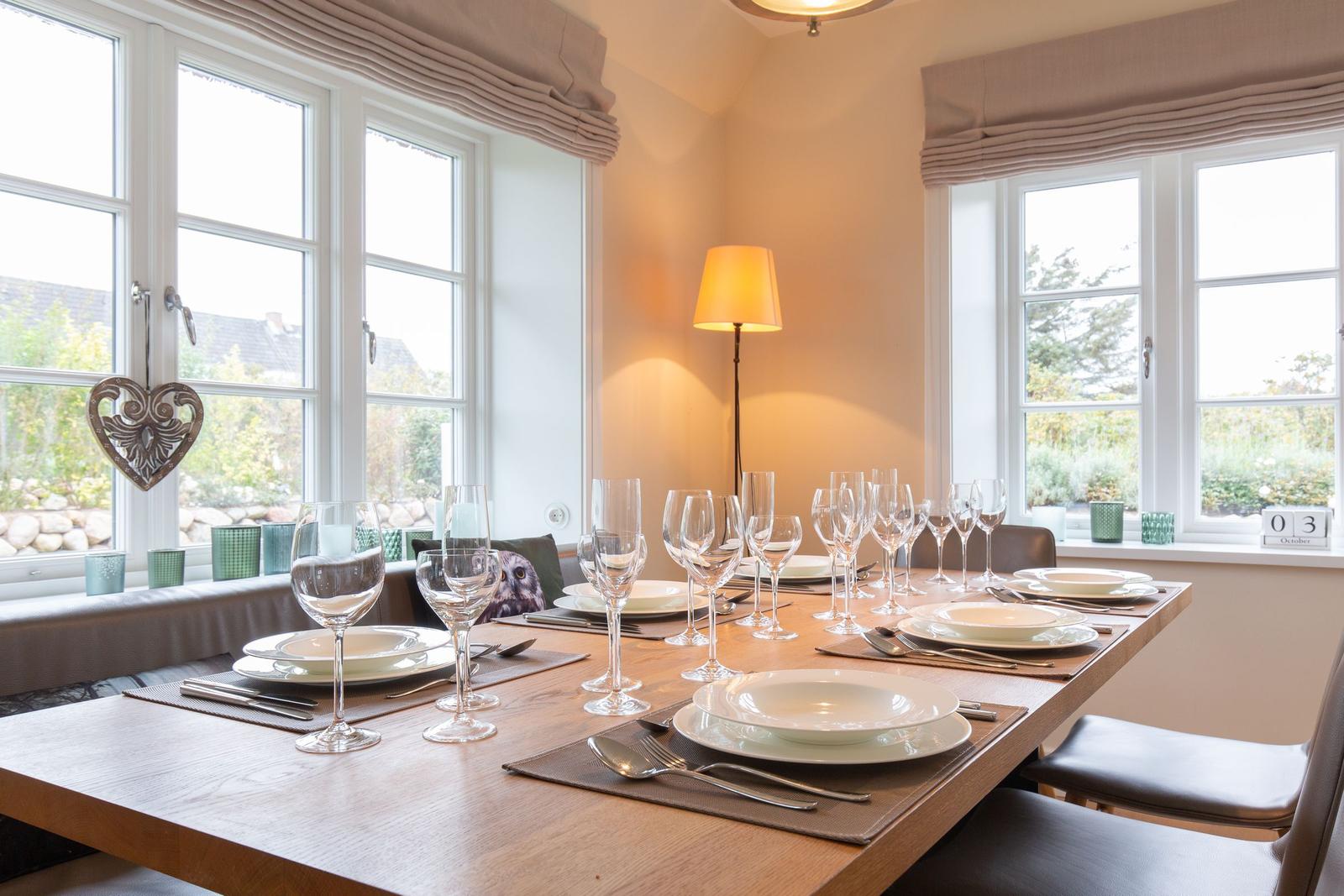 Esstisch mit Platz für sechs Personen, Fenster mit Blick auf Garten.
