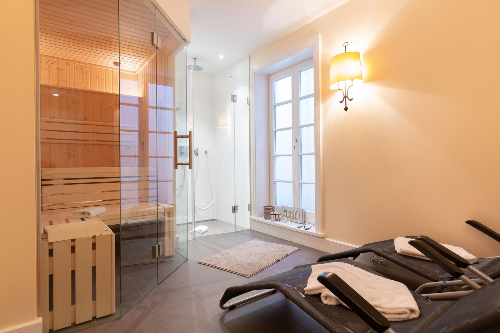 Sauna, Dusche und Liegen im Wellnessbereich.