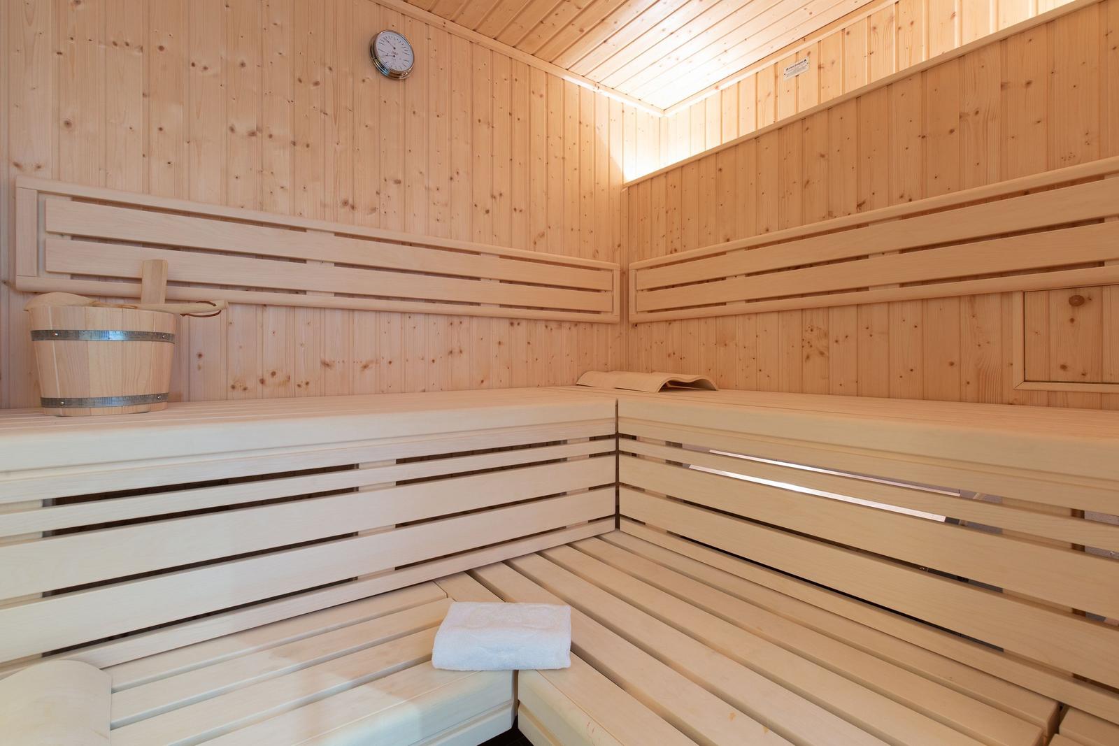 Sauna mit Holzbank, Eimer und Handtuch