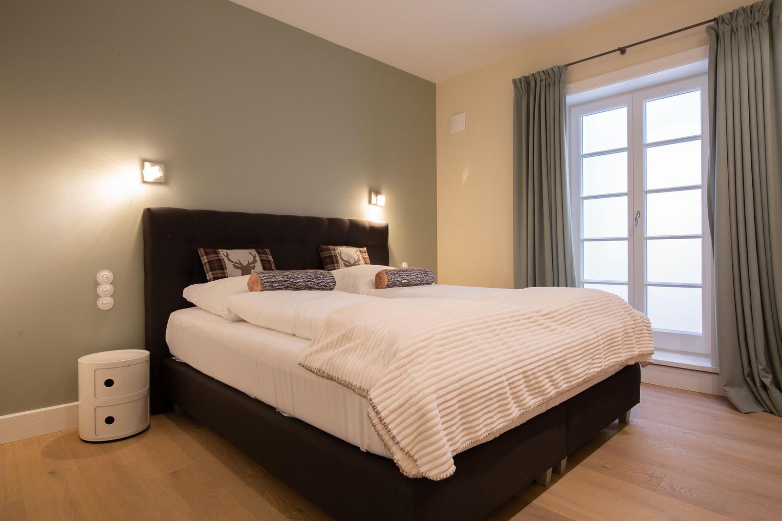 Schlafzimmer mit Bett, Fenster und Nachttisch