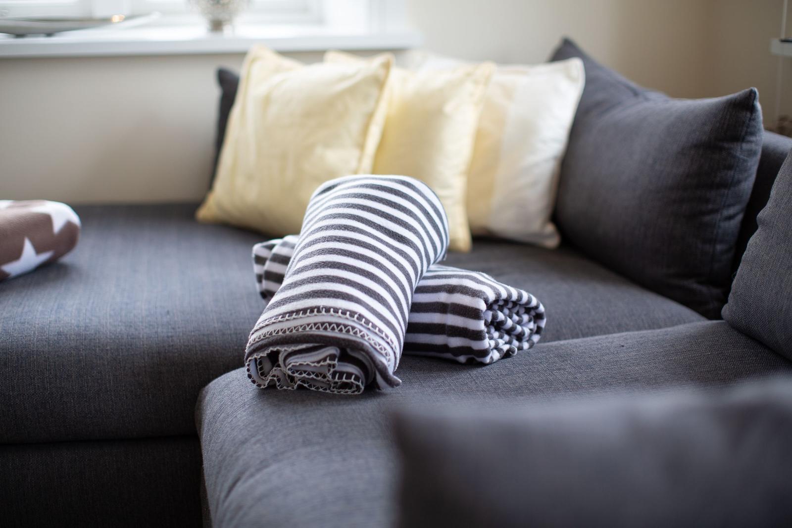 Grafe Sofa mit Kissen und gefalteten Decken
