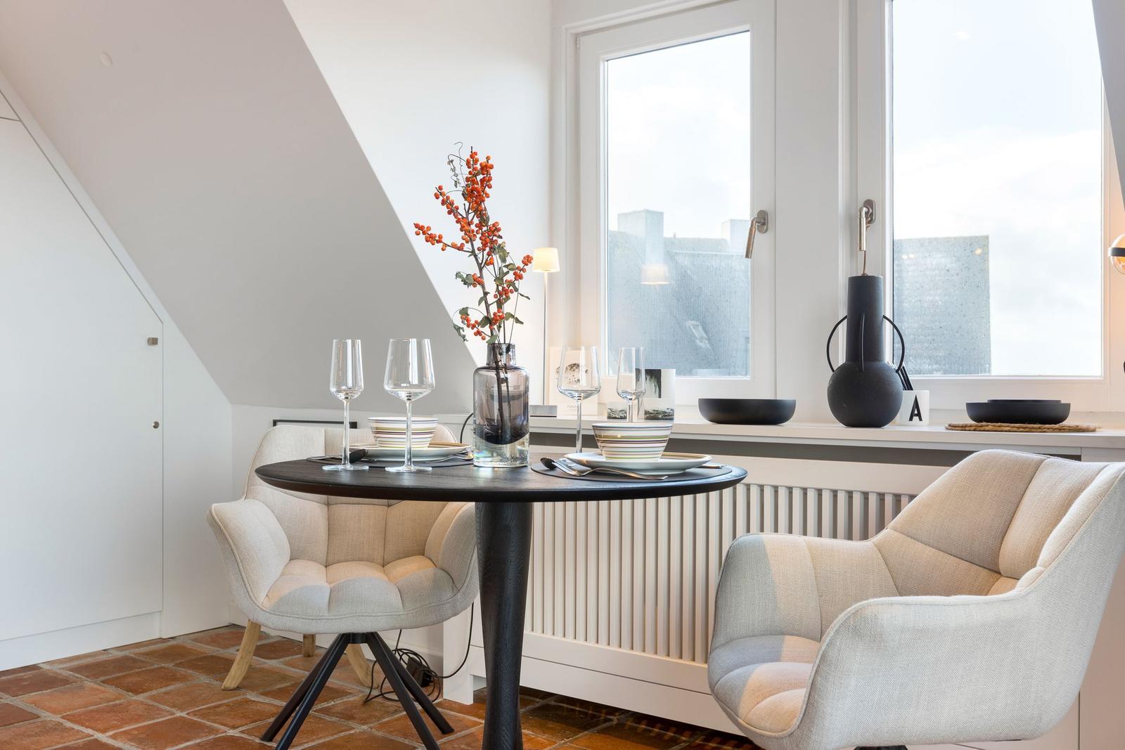 Rundtisch mit zwei Stühlen unter Fenster mit Blick auf Stadt