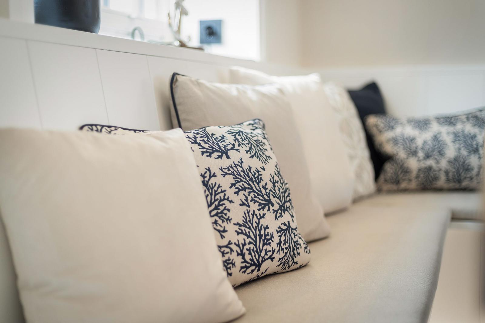 Sofa with beige and blue cushions featuring coral pattern