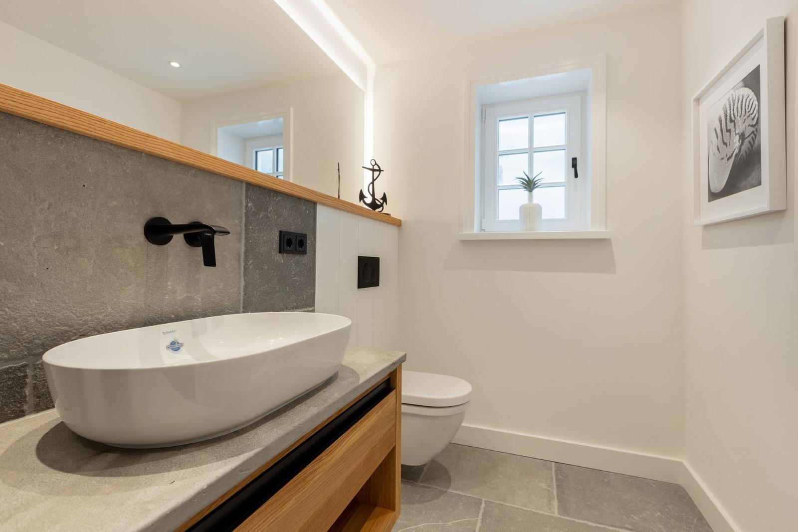 Bathroom with sink, toilet, and window