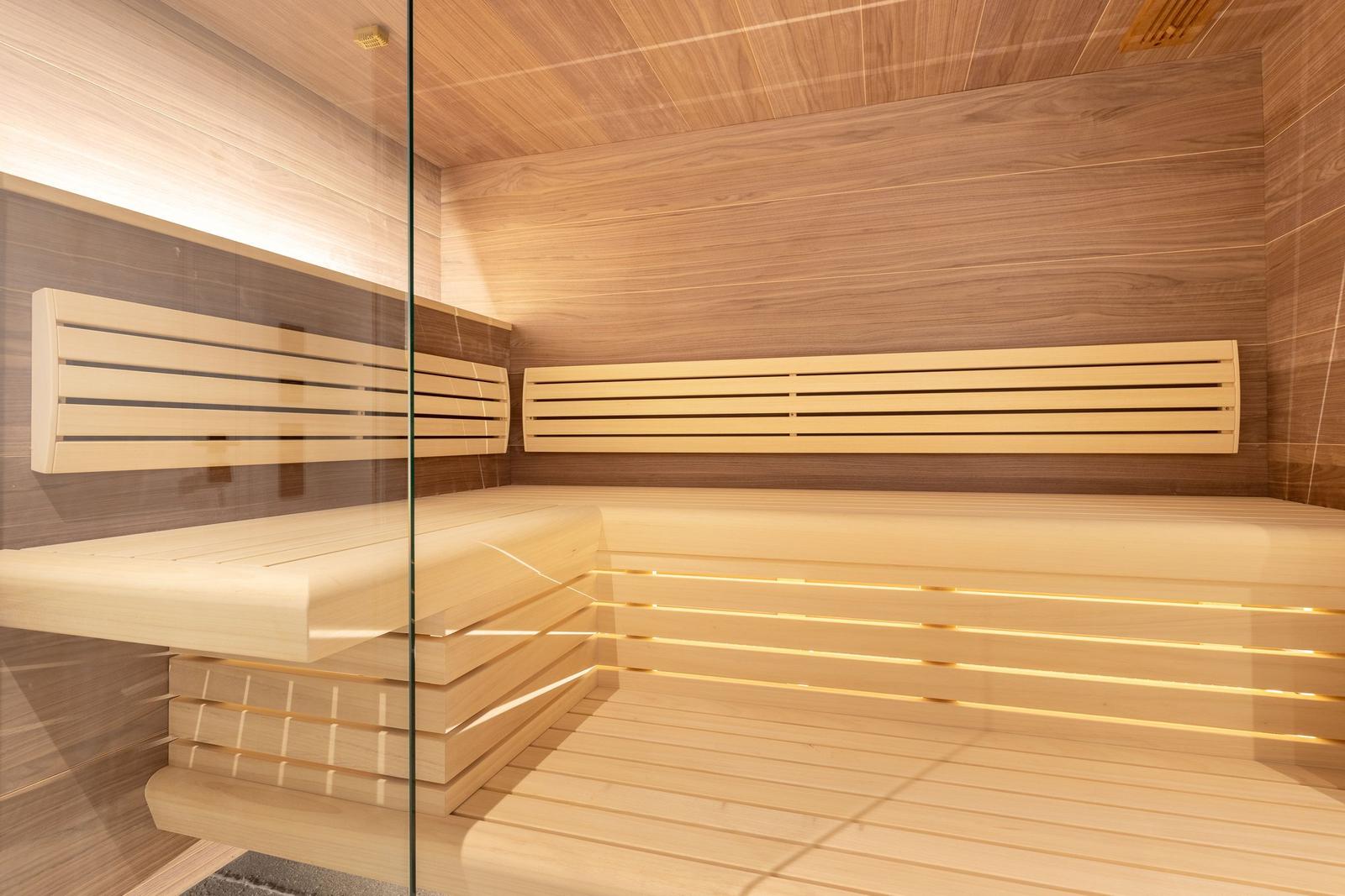 Sauna with wooden benches and glass wall
