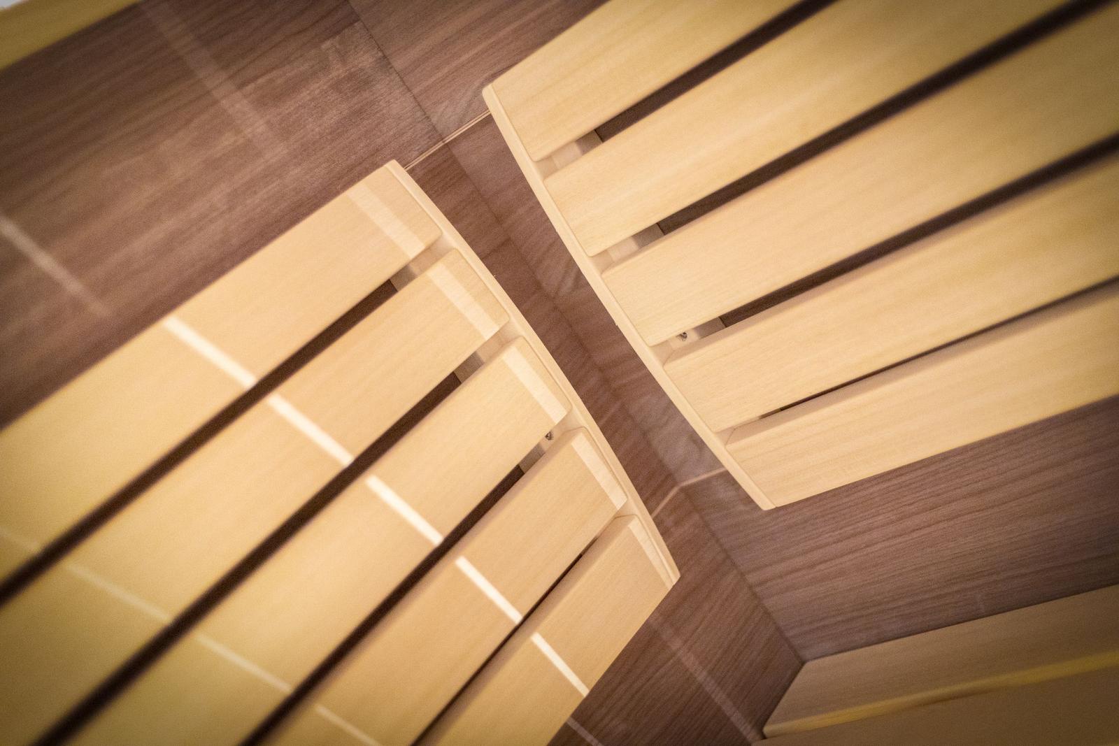Two rows of wooden benches in a sauna with wooden floor