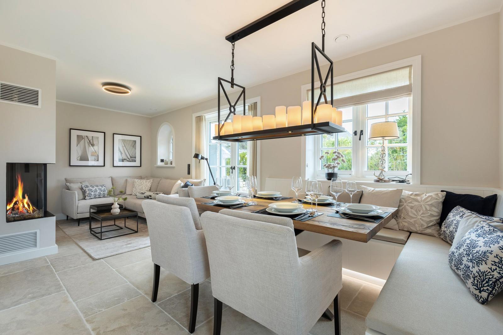 Dining room with table, chairs, and windows. Living area with sofa and fireplace.
