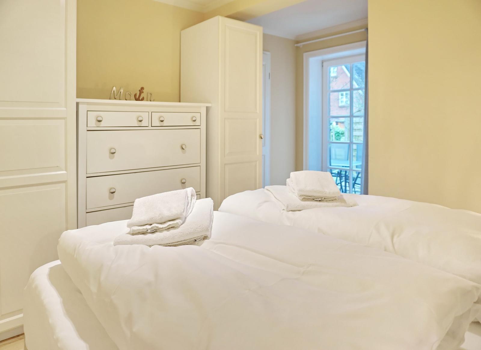 Room with bed, wardrobe, and window to outdoor terrace.