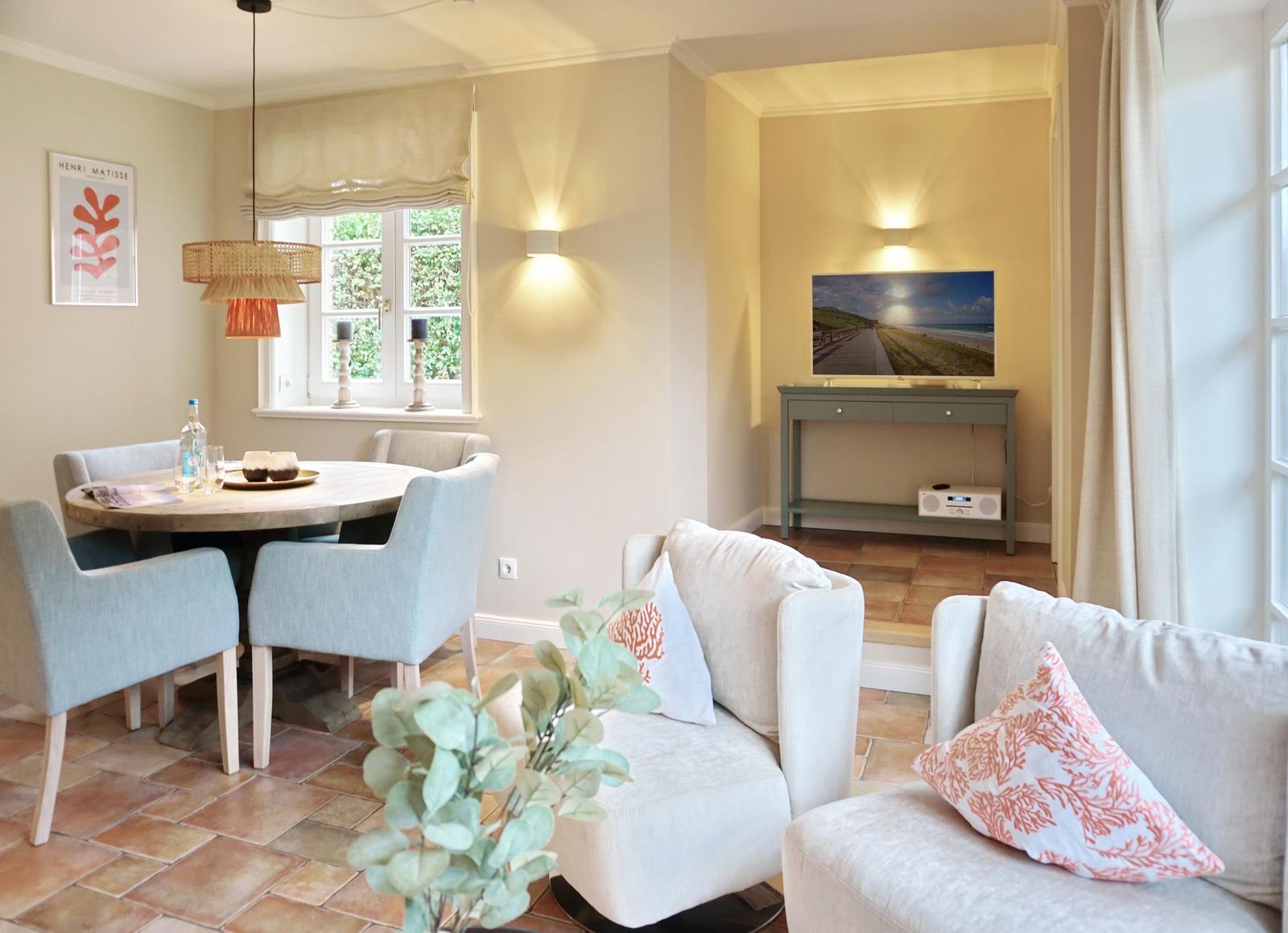 Living and dining area with sofa, table, and TV.